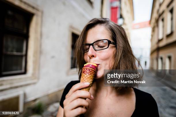 carefree young woman enjoying yummy ice cream - ice cream cone stockfoto's en -beelden