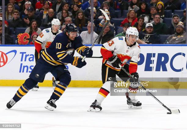Johnny Gaudreau of the Calgary Flames skates with the puck as Jacob Josefson of the Buffalo Sabres pursues during the third period at KeyBank Center...