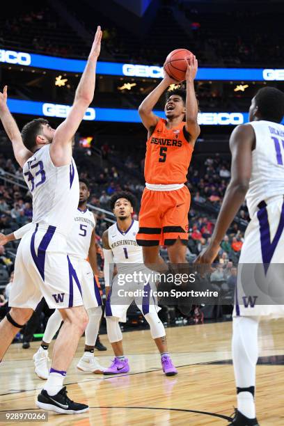 Oregon State guard Ethan Thompson shoots over Washington forward Sam Timmins during the first round game of the mens Pac-12 Tournament between the...