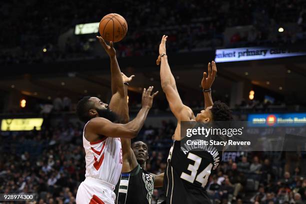 James Harden of the Houston Rockets shoots over Tony Snell and Giannis Antetokounmpo of the Milwaukee Bucks during the second half of a game at the...
