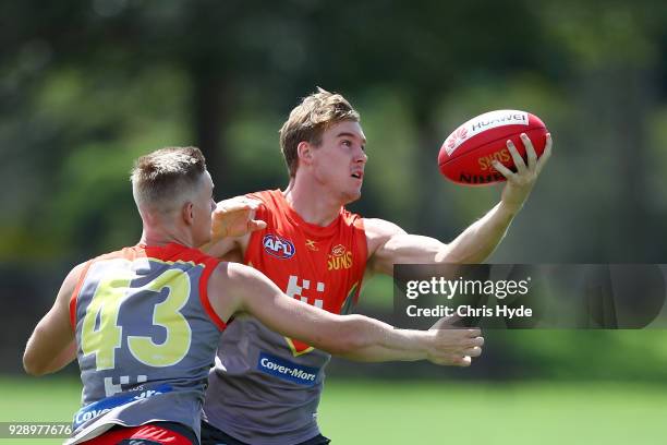 Tom Lynch and Max Spencer compete for the ball during a Gold Coast Suns AFL training session at Bond University AFL Field on March 8, 2018 in Gold...