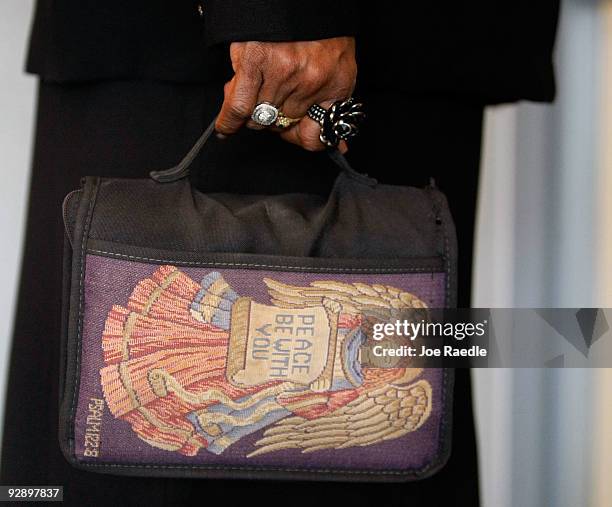 Women carries a bag to a church service at the Comanche Chapel on the grounds of Fort Hood where the pastor included a prayer for the victims the...