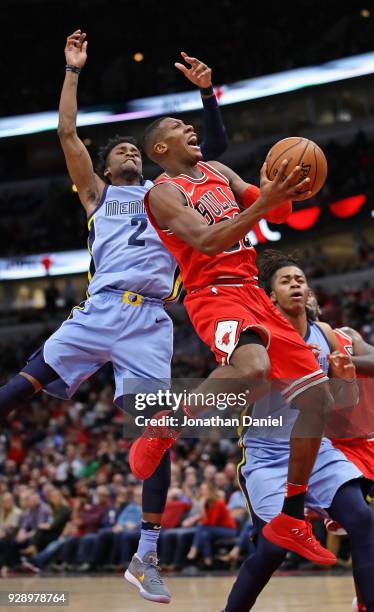 Kris Dunn of the Chicago Bulls drievs to the basket past Kobi Simmons of the Memphis Grizzlies at the United Center on March 7, 2018 in Chicago,...