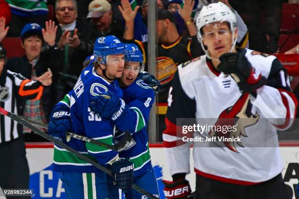 Richard Panik of the Arizona Coyotes looks on as Jussi Jokinen of the Vancouver Canucks is congratulated by teammate Brendan Leipsic after scoring...