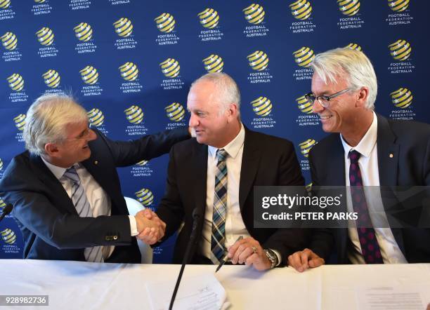 Sydney FC coach Graham Arnold shakes hands with Football Federation Australia chairman Steven Lowy and Chief Executive Officer David Gallop after he...