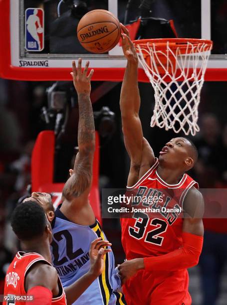 Kris Dunn of the Chicago Bulls blocks a shot by Xavier Rathan-Mayes of the Memphis Grizzlies at the United Center on March 7, 2018 in Chicago,...