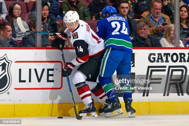 Reid Boucher of the Vancouver Canucks checks Richard Panik of the Arizona Coyotes during their NHL game at Rogers Arena March 7, 2018 in Vancouver,...