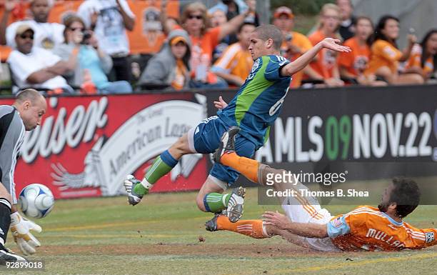 Brian Mullan of the Houston Dynamo shoots on goal while Osvaldo Alonso and goalie Kasey Keller of the Seattle Sounders defend during Game Two of the...