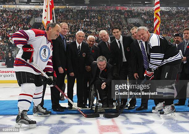 Jim Gregory, Bill Hay, Steve Yzerman, Brian Leetch, Lou Lamoriello, Luc Robitaille, and Brett Hull take part in the ceremonial faceoff between Bryan...