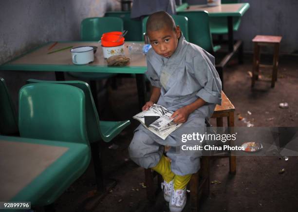 Boy reads a book after lunch at the Shaolin Kung Fu Training Base at the foot of the Songshan Mountain on October 30, 2009 in Dengfeng of Henan...