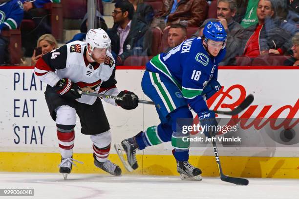 Richard Panik of the Arizona Coyotes checks Jake Virtanen of the Vancouver Canucks during their NHL game at Rogers Arena March 7, 2018 in Vancouver,...