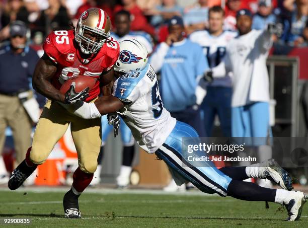 Vernon Davis of the San Francisco 49ers runs after a catch as Keith Bulluck of the Tennessee Titans defends during an NFL game on November 8, 2009 at...