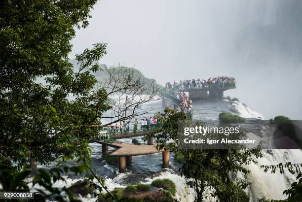 toeristen bij de iguaçu falls, braziliaanse kant - argentina devils throat stockfoto's en -beelden