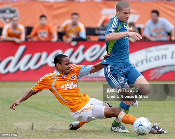 Ricardo Clark of the Houston Dynamo slide tackles Osvaldo Alonso of the Seattle Sounders during Game Two of the 2009 MLS Western Conference Semifinal...