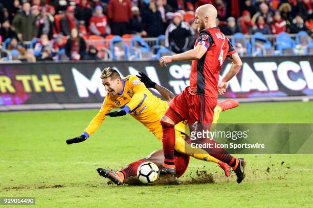 Chris Mavinga of Toronto FC tackles from behind Ismael Sosa of Tigres UANL during extra time of the second half of the CONCACAF Champions League...