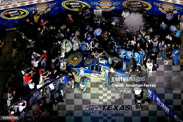 Kurt Busch, driver of the Miller Lite Dodge, celebrates with the checkered flag on victory lane after winning the NASCAR Sprint Cup Series Dickies...