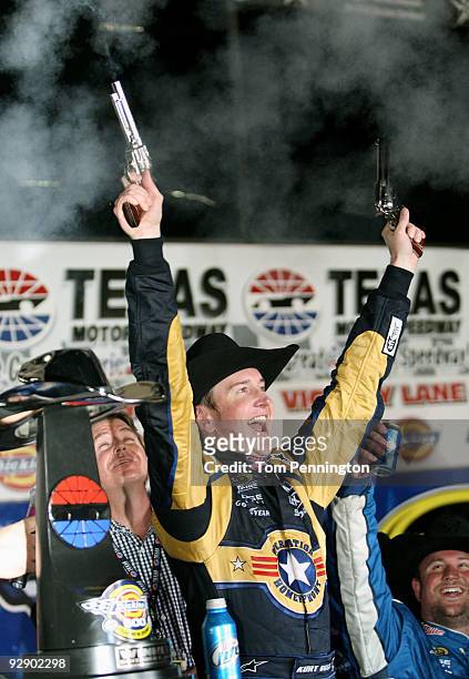 Kurt Busch, driver of the Miller Lite Dodge, celebrates by firing two Beretta's into the air on victory lane after winning the NASCAR Sprint Cup...