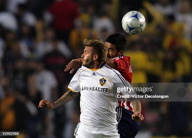 David Beckham of the Los Angeles Galaxy goes up for a high ball against Paulo Nagamura of Chivas USA in the first half during Game 2 of the MLS...