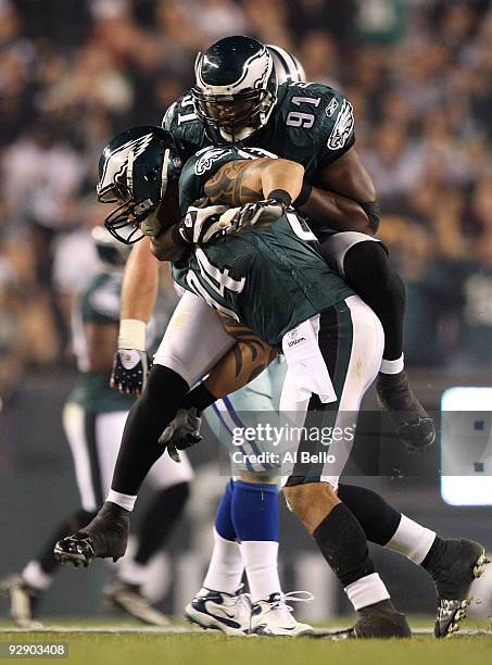 Jason Babin and Chris Clemons of the Philadelphia Eagles celebrate after Babin sacked quarterback Tony Romo of the Dallas Cowboys in the second...