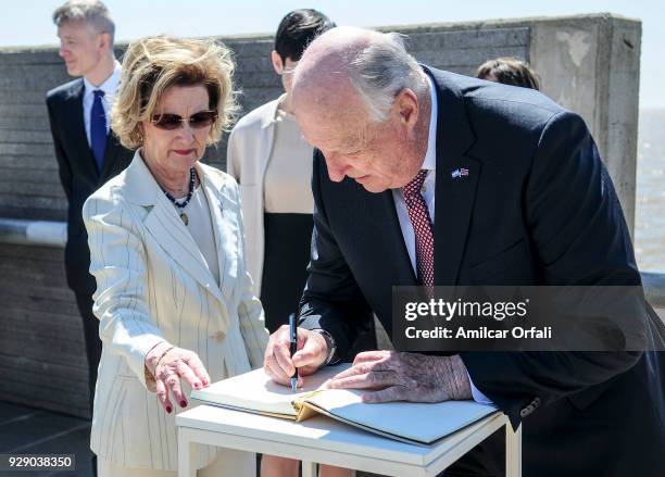 King Harald V of Norway signs the visitor's book next to Queen Sonja of Norway during a visit to 'Parque de la Memoria' as part of an official visit...