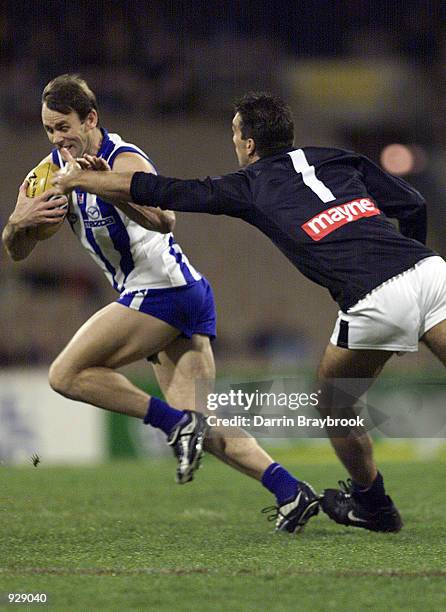 David King for the Kangaroo's, attempts to out run Stephan Silvagni for Carlton, in the match between the Kangaroos and the Carlton Blues, during...