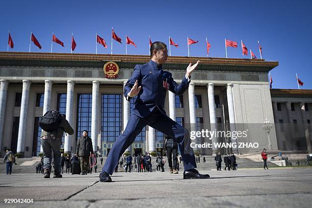 Delegate performs tai chi as he leaves after the second plenary session of the Chinese People's Political Consultative Conference at the Great Hall...