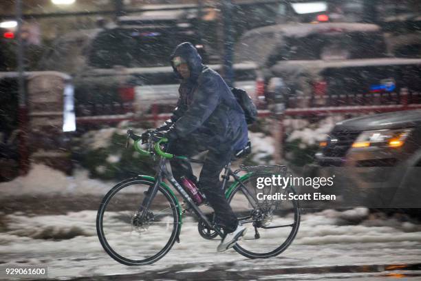 Person rides a bike down Washington St. As another major nor'easter barrels Into northeastern U.S. On March 8, 2018 in Boston, United States. Large...