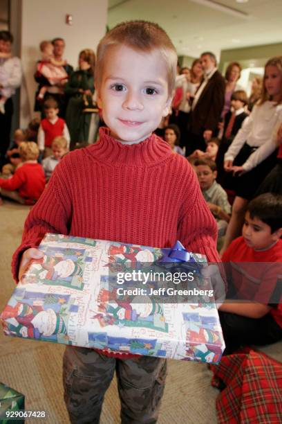 Boy holding a present at an office Christmas party in Miami.