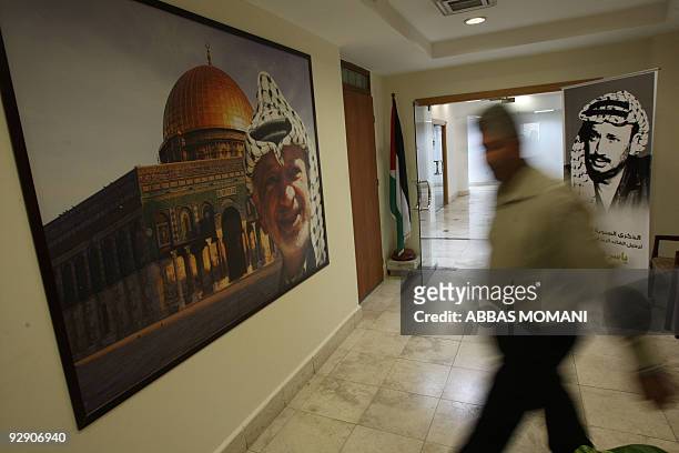 Man walks past portraits of late Palestinian leader Yasser Arafat, one of them superimposed on a pictur of the Jerusalem's Dome of the Rock mosque,...