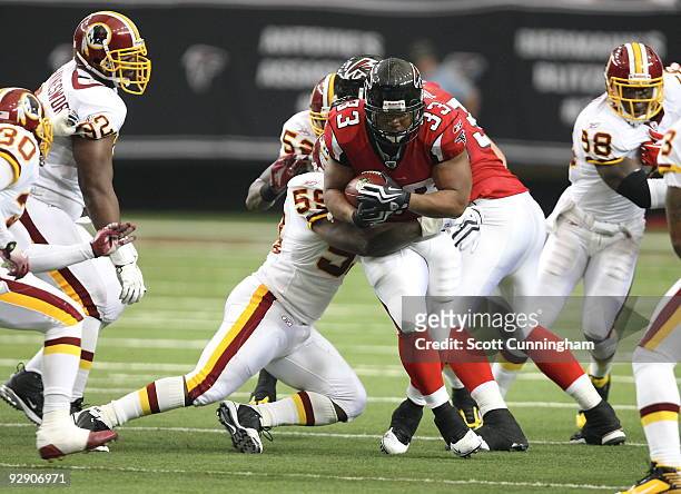 Michael Turner of the Atlanta Falcons carries the ball against London Fletcher of the Washington Redskins at the Georgia Dome on November 8, 2009 in...