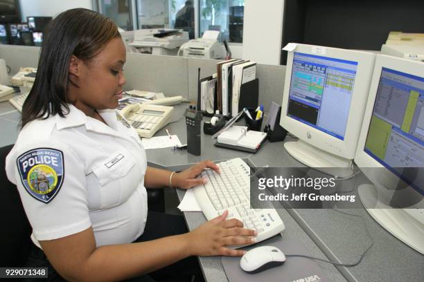 Female dispatcher working on computer monitors in the Police Department at North Miami Beach.