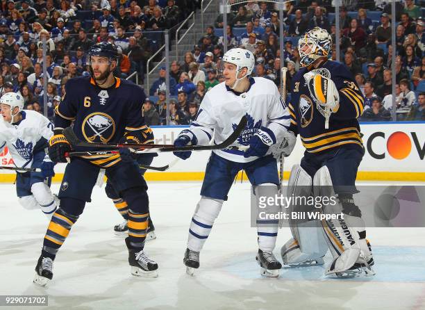 Marco Scandella and Chad Johnson of the Buffalo Sabres defend during an NHL game against Zach Hyman of the Toronto Maple Leafs on March 5, 2018 at...