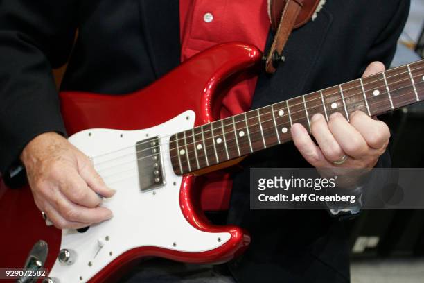 Man playing an electric guitar at an office Christmas party in Miami.