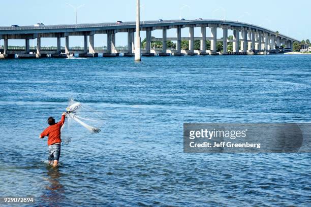Man casting a fishing net into the Indian River.