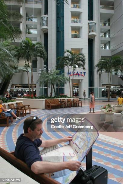 Man looking at a map outside Hyatt Hotel in Orlando Airport.