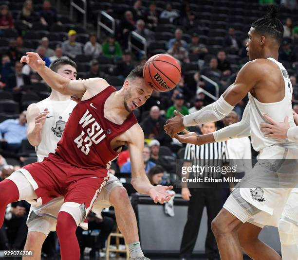 Drick Bernstine of the Washington State Cougars and Kenny Wooten of the Oregon Ducks fight for a rebound during a first-round game of the Pac-12...