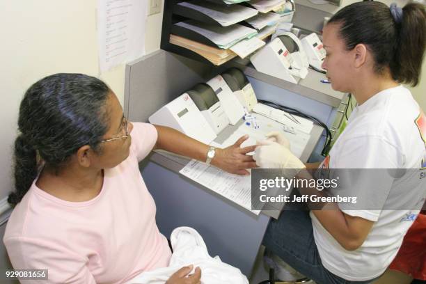 Woman receiving a free cholesterol test at the Miami Beach, Community Health Center.