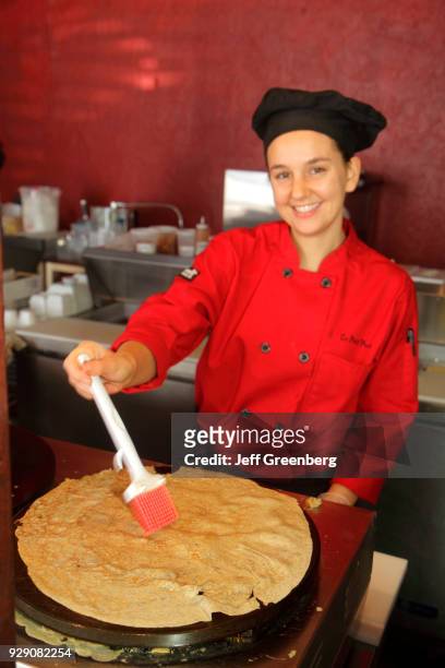 Woman making a crepe at Le Petit Paris Café.
