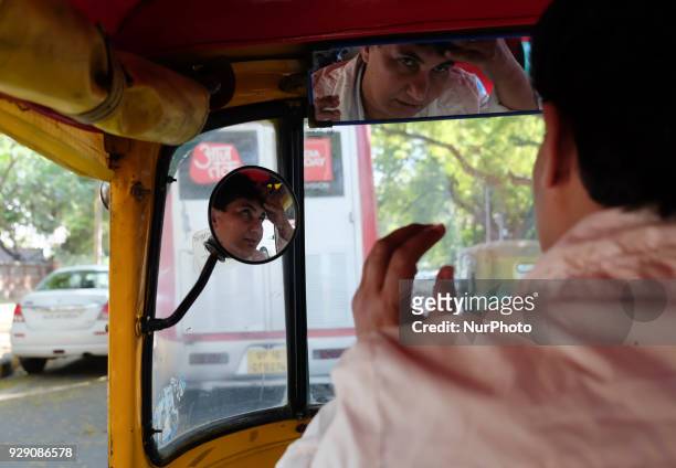 Sunita Choudhary, 40 - North India's first auto-rickshaw driver - fixes her hair looking into her auto-rickshaw's mirror on 6th March, 2018 in New...