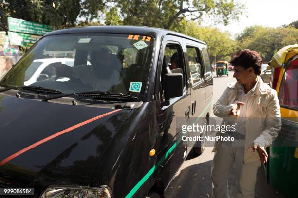 Sunita Choudhary - North India's first auto-rickshaw driver - guides a taxi driver to their destination as they stop to seek directions along a...