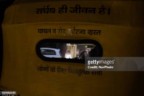 Reflection of Sunita Choudhary - North India's first auto-rickshaw driver - is seen on the mirror behind her auto-rickshaw with a notification that...