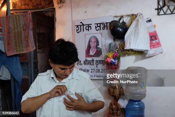 Sunita Choudhary - North India's first auto-rickshaw driver - puts on her badge as she prepares to leave for work from her house in South Delhi on...