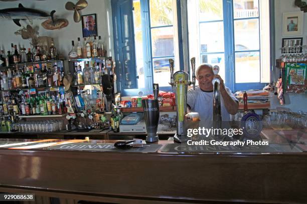 Barman pulling pints of beer Inside Gleneagles Bar pub at Mgarr, Gozo, Malta.