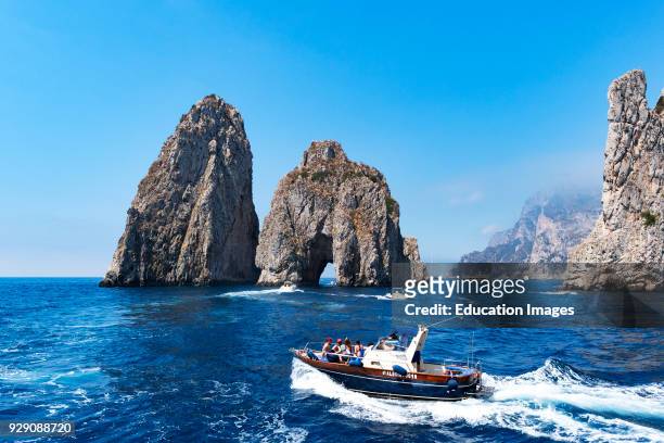 Boats Cruising Around The Faraglioni Rocks In The Tyrrhenian Sea, Along The Coast Of The Island Of Capri, Italy.