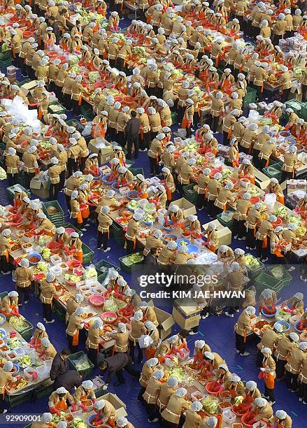 About 2,000 South Korean housewives make Kimchi, Korea's traditional spicy, pickled and fermented vegetables, in front of the City Hall as part of a...