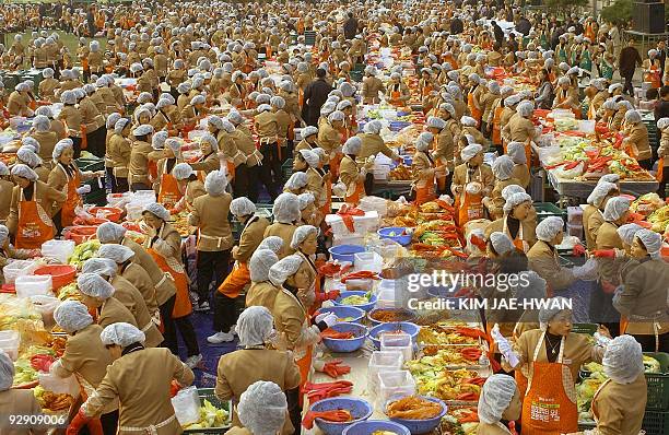 About 2,000 South Korean housewives make Kimchi, Korea's traditional spicy, pickled and fermented vegetables, in front of the City Hall as part of a...