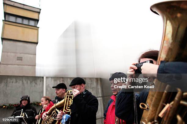 Brass band waits to play at a commemorative ceremony at a still-existing section of the Berlin Wall at the Bernauer Strasse memorial on the 20th...