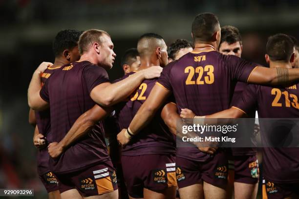 Matthew Lodge of the Broncos stands in a huddle with team mates before the round one NRL match between the St George Illawarra Dragons and the...