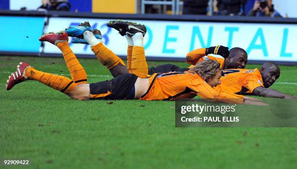 Hull City's Nigerian midfielder Seyi Olofinjana celebrates scoring against Stoke City with English midfielder Jimmy Bullard and US forward Jozy...