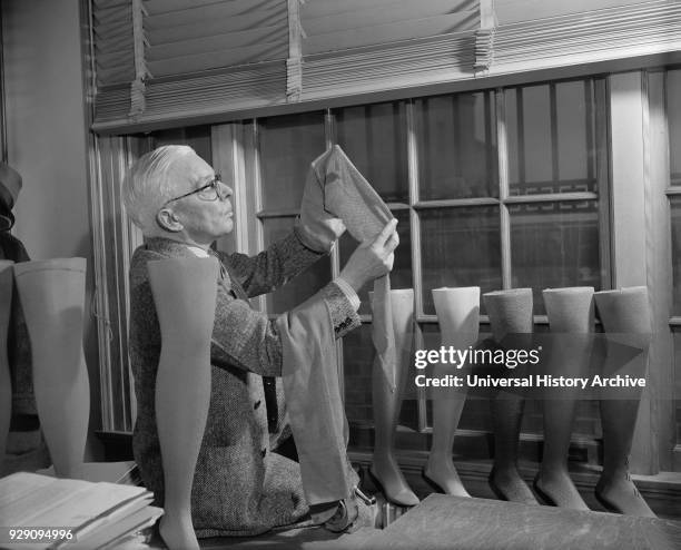 David H. Young, Agriculture Department Fabric Technician, Examining Cotton Stockings, which is trying to be Popularized over Silk and Nylon,...